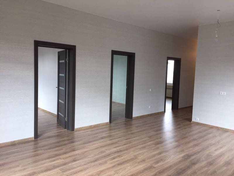 Внутри дома: комната с дверями в спальни, ламинат